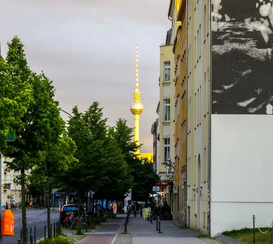 Berliner Fernsehturm über einer Straße mit Bäumen