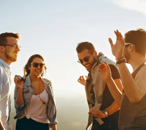 Junge Leute lachen gemeinsam im Sonnenlicht